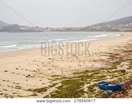 Blue Boat Tied To The Shore At Low Tide - Praia De Langosteira, Galicia, Spain