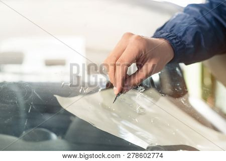 Close Up Automobile Glazier Worker Fixing And Repair Windscreen Or Windshield Of A Car In Auto Servi