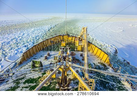 Lapland. Wide strip of ice crumb spreads behind the icebreaker. Unforgettable excursion to the arctic tourist cruise on the sea icebound. The concept of active and extreme tourism