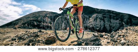 Mountain bike MTB biking athlete man in mountains landscape jumping riding bicycle. Professional bicycle rider training outdoors. Sport and fitness panoramic banner background.