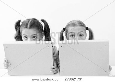 Little Awkward Girls Hide Faces Behind File Folders. Little Awkward Girls Enjoy Playing Together.