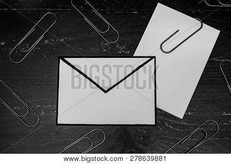 Funny Metaphor Of Inbox With Email Envelop And Attachment Clip On Real-life Desk
