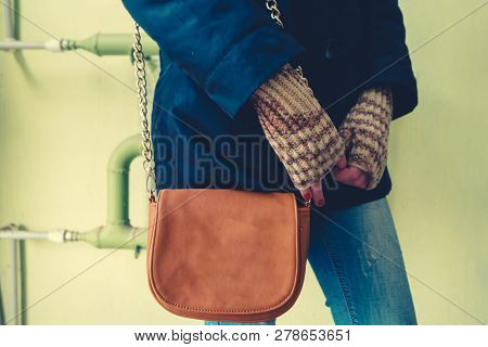 Girl In Knitted Gloves Standing In Front Of Green Wall With Leaser Shoulder Bag