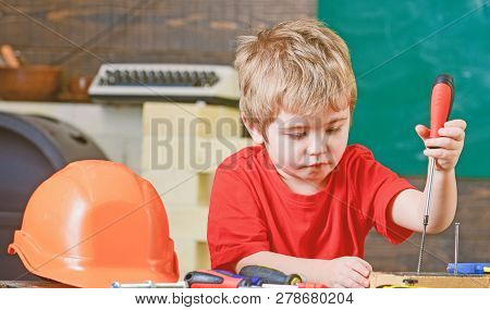 Closeup Blond Kid In Workshop. Boy Binding Screws To Wooden Board. Concentrated Child Learning New S