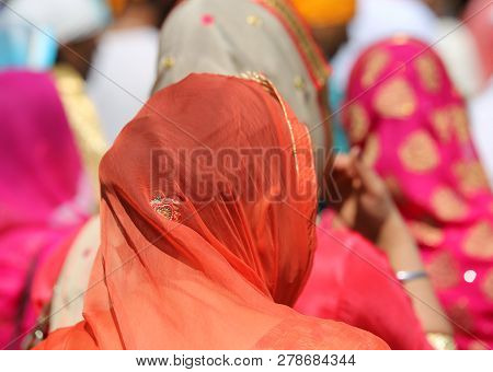 Woman With Head Covered By A Colorful Orange Veil During An Outdoor Religious Parade
