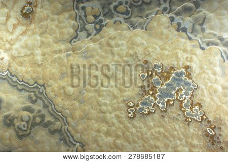 Background From A Light Yellow Natural Stone Onyx With Bubbles And Gray Stains On The Surface Is Cal