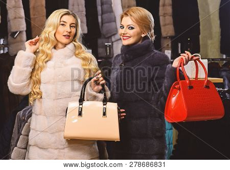 Women In Fur Coats With Bags In Fur Shop. Winter Clothing And Glamour Concept. Ladies With Makeup Sh