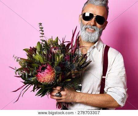 Handsome Older Stylish Bearded Man In White Shirt Holding A Bouquet Of Flowers Over Pink Background 