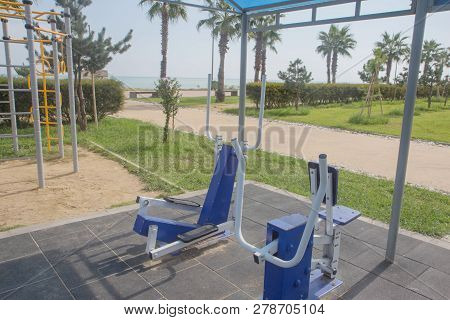 Exercise Equipment In A Public Park In A Sunny Day. Sidewalk Outdoor Exercise Equipmen