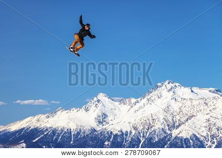 Sochi, Russia - March 25, 2014: Man Snowboarder Flies Freestyle From Big Air Jump Making Trick On Ch