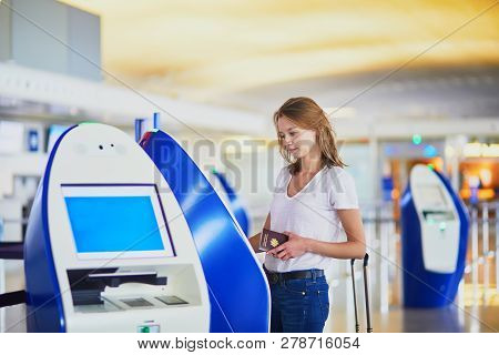 Young Woman In International Airport Doing Self Check-in