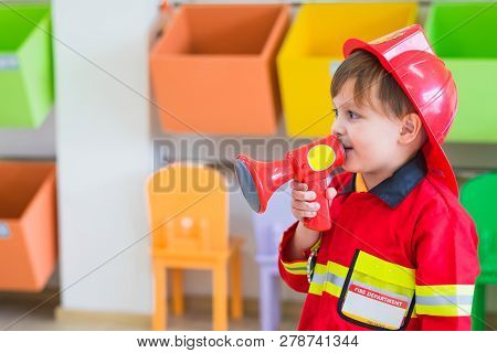 Caucasian Boy Kid Dress Up To Fireman And Use Speaker At Roll Play Classroom,kindergarten Preschool 
