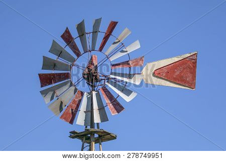 An Old Windmill Stands Against A Clear Blue Texas Sky.