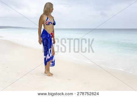 Woman With Australian Flag Draped Around Her On Beach