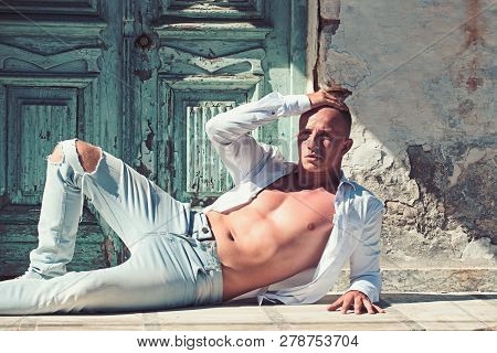 Sexy Macho Man With Bare Chest And Muscular Torso Relax At Wooden Door. Fashion Model In Jeand And S