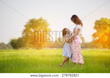 Mother And Little Cute Daughter Playing Together In Park (rice Field)