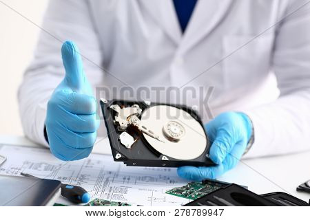Male Repairman Wearing Blue Gloves Is Holding Hard Drive From Computer Laptop In Hands Show Ok Thumb