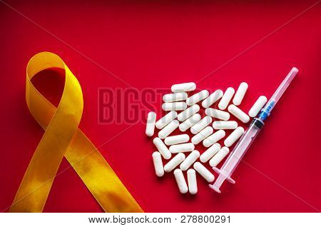 Golden Ribbon And Medicine. Concept - A Symbol Of Childhood Cancer, Pediatric Oncology
