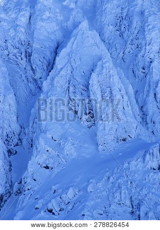 Bucura II Peak, 2372m. Winter alpine landscape in National Park Retezat, Carpathians, Romania, Europe. Snow covered moutains scenery