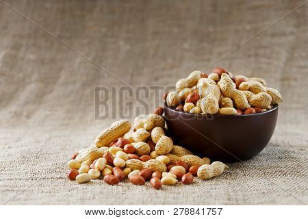 Peanuts In The Shell And Peeled Close-up In Cups. Roasted Peanuts In Their Shells And Peeled Against