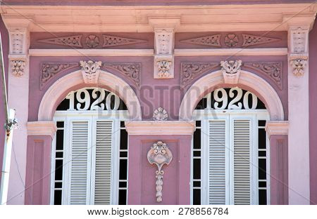Neoclassical architecture with column in pale rose with white door and pillars in Vedado Havana in Cuba