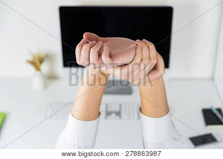 Stretching Arms In Sparse Office Workplace. Hands Of An Employee In Front Of Modern Desktop, Overwor