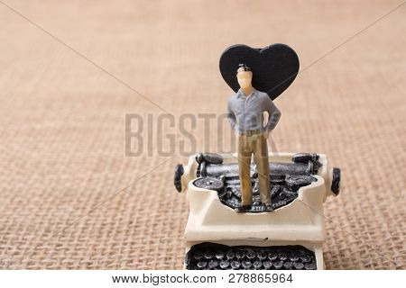 Retro Syled Tiny Typewriter Model On A Canvas Background