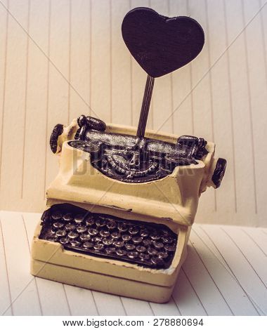 Retro Syled Tiny Typewriter Model On A Paper Background