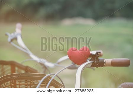 A Little Red Heart Pillow On The Bicycle Handlebar.