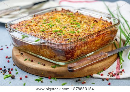 Potato Kugel A Traditional Jewish Dish In A Glass Pan On A Wooden Serving Board, Selective Focus.