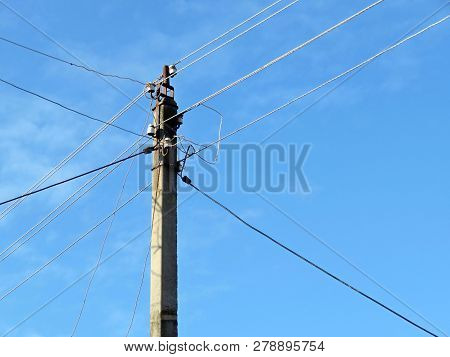 Old Power Line Post With Electrical Wires And Capacitors Isolated On Blue Sky Background. Electricit
