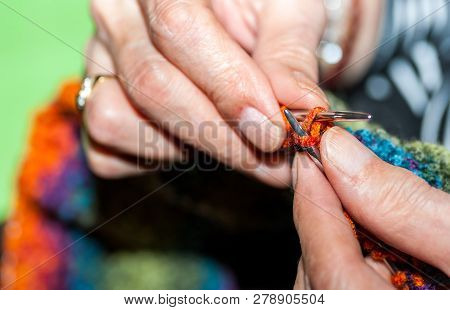 Hand Of Old Woman Holding Knitting Needles And Multi Colored Wool For Woolwork Of Warm Sweater For C