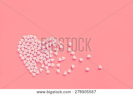Pink Heart Shaped Candies On A Soft Pink Paper Background. Broken Heart Or Pearts Gethering Love Con