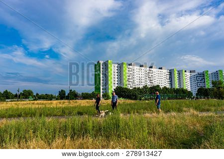 Poznan, Poland - July 10, 2018: People And A Dogs Walking On A Trail Between High Plants. High Apart