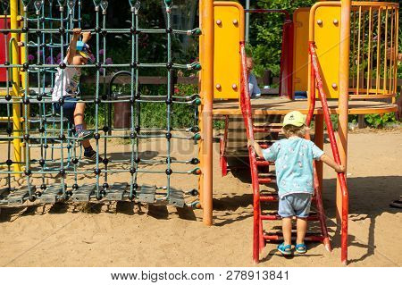 Poznan, Poland - July 29, 2018: Young Boys Walking On Steps And Climbing On A Rope Net Of A Equipmen
