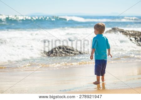Happy Boy Running On The Beach In The Waves