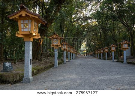  Miyazaki, Japan - November 5, 2018: Long lane with lanterns through the park to the torii of the Miyazaki Jingu shrine  