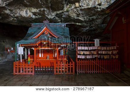 Miyazaki, Japan - November 6, 2018: The  brightly painted Udo Shrine is set in a cave on the side of a cliff with rabbit ema beside