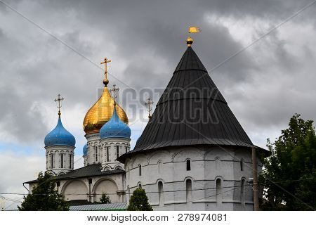 Russia, Moscow, July 2018 - Novospassky Monastery. Fortress Wall With Tower And Domes Of The Temple 
