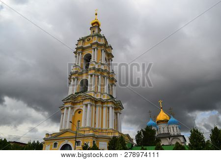 Bell Tower Of Novospassky Monastery In Moscow Against A Dark Cloudy Sky. Russia