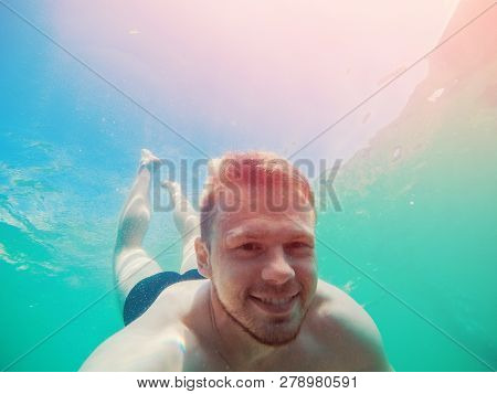 Happy Man Dives Under Sea With Action Camera, Takes Selfie Photo. Concept Snorkeling.