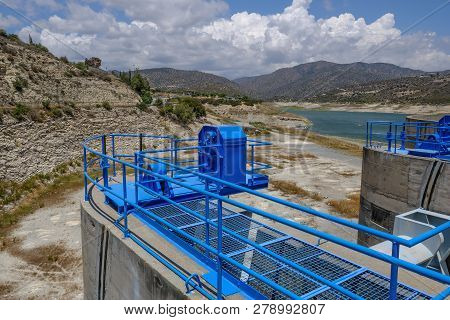 Sluice Mechanism Beside The Dam In Germasogeia In Cyprus.  Shot Shows The Dam With Mountains Behind.