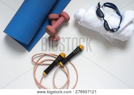 Jump Rope, Yoga Mat, Dumbbells, White Bath Towel, Swimming Goggles, Close-up On A White Background
