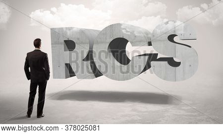 Rear view of a businessman standing in front of RCS abbreviation, modern technology concept