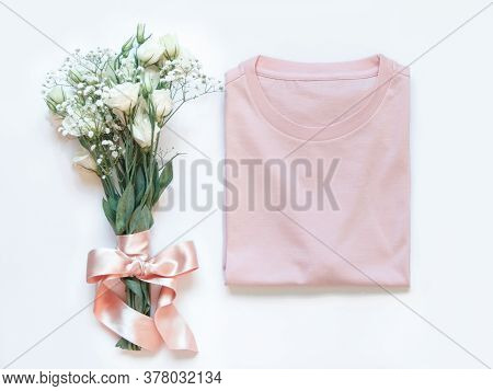 Mockup Of A Folded T-shirt Placed Near White Flowers Top View