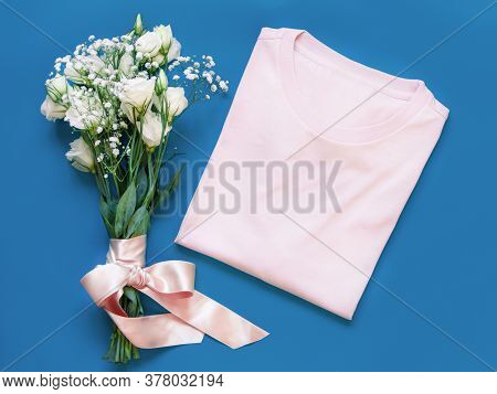 Mockup Of A Folded T-shirt Placed Near White Flowers Top View