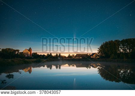 Dobrush, Belarus. Comet Neowise C2020f3 In Night Starry Sky Reflected In Small Lake Waters