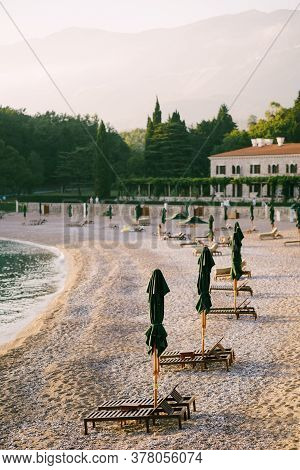 Wooden Loungers On A Sandy Platform, At Sunset. Villa Milocher In Montenegro, Near The Island Of Sve