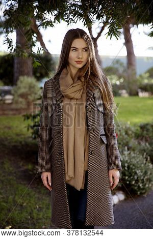 Young Long Hair Woman Model Of Clothes In The Garden In Spring Posing