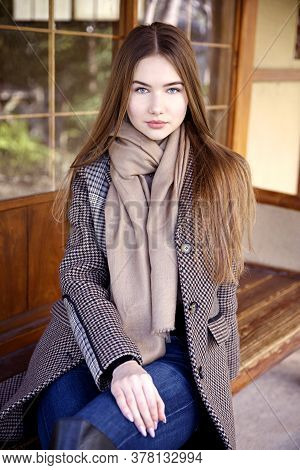 Young Long Hair Woman Model Of Clothes In The Garden In Spring Posing